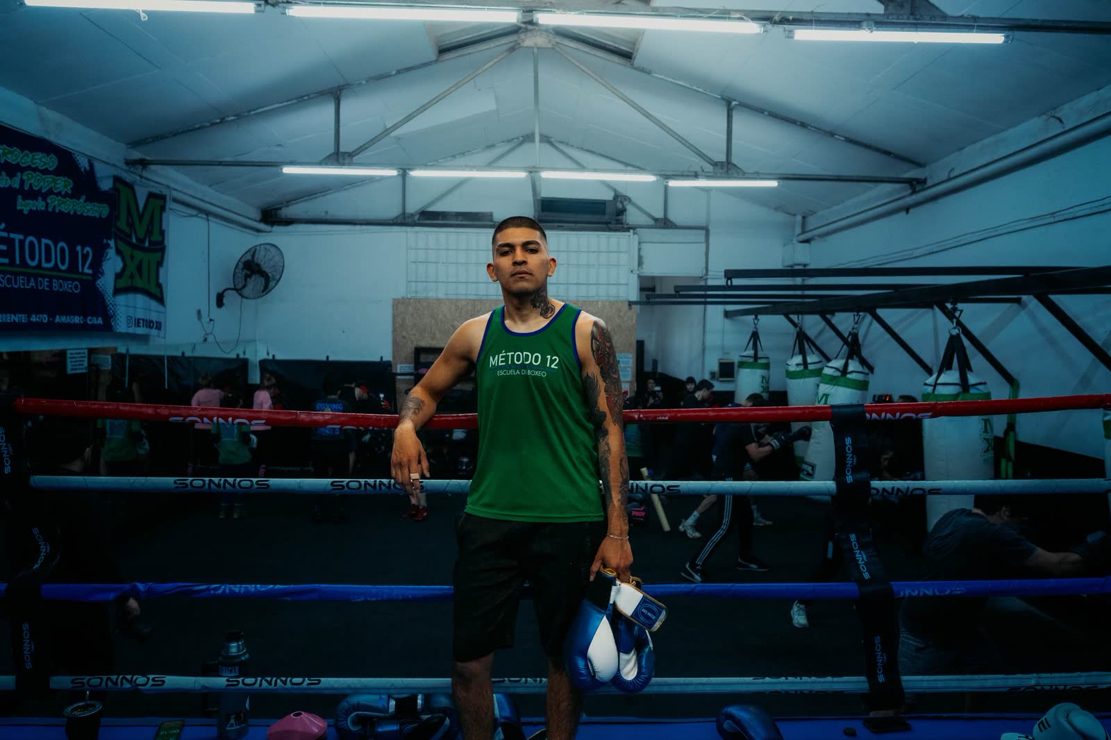 Boxeador de pie en el ring de su gimnasio, listo para entrenar
