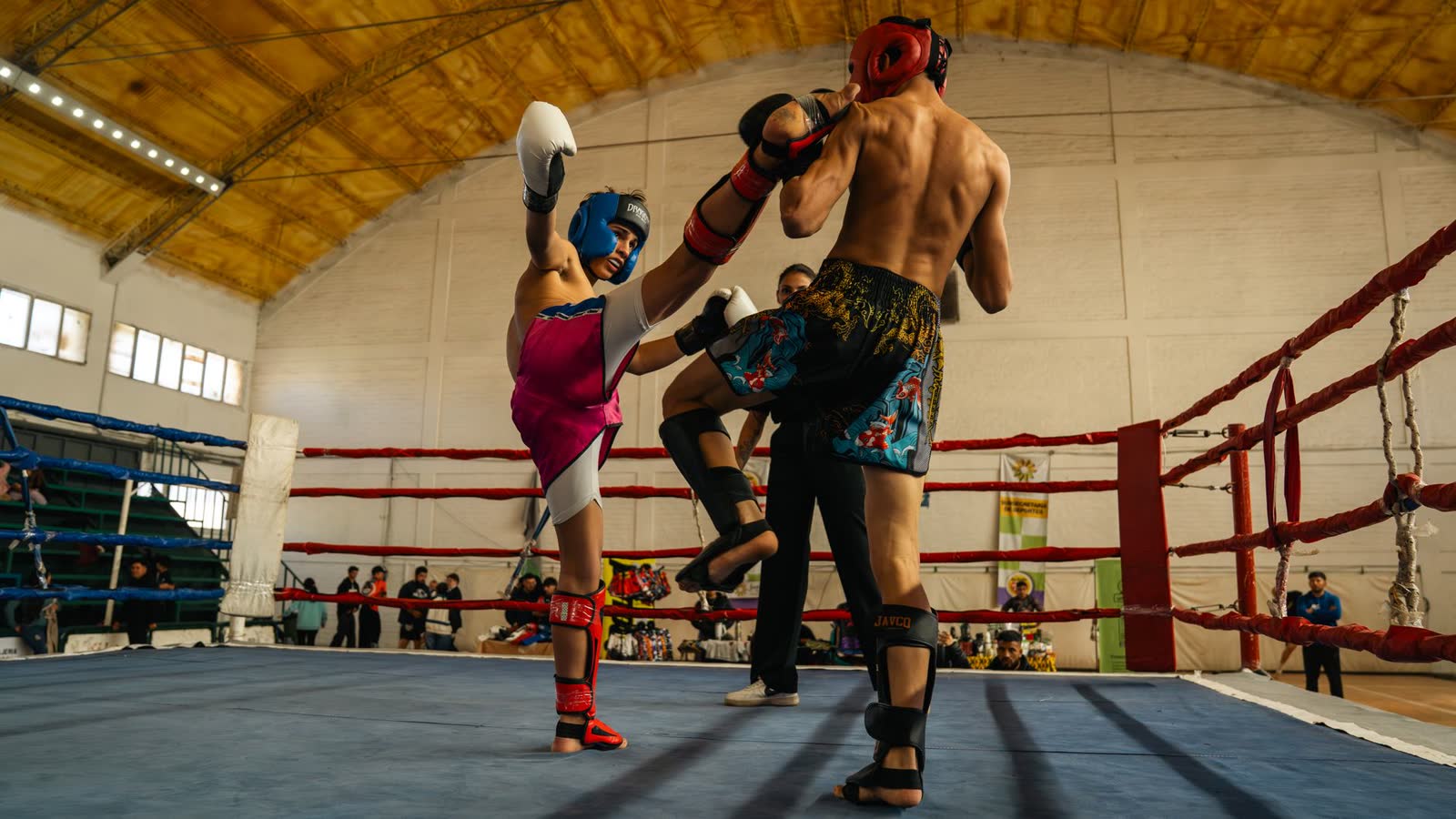 Dos peleadores de muay thai intercambiando en el ring durante un combate